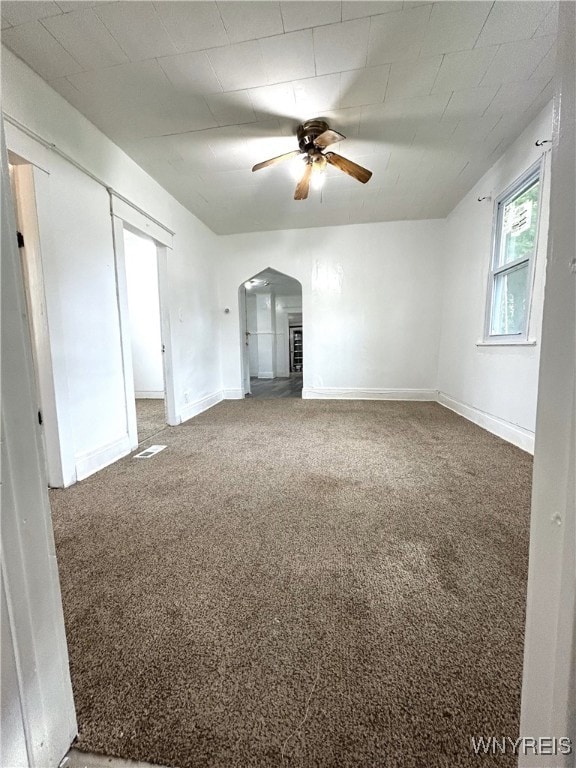 carpeted spare room featuring ceiling fan