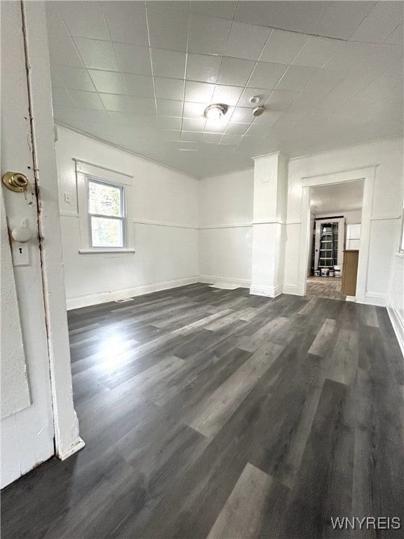 interior space featuring a drop ceiling and dark hardwood / wood-style floors