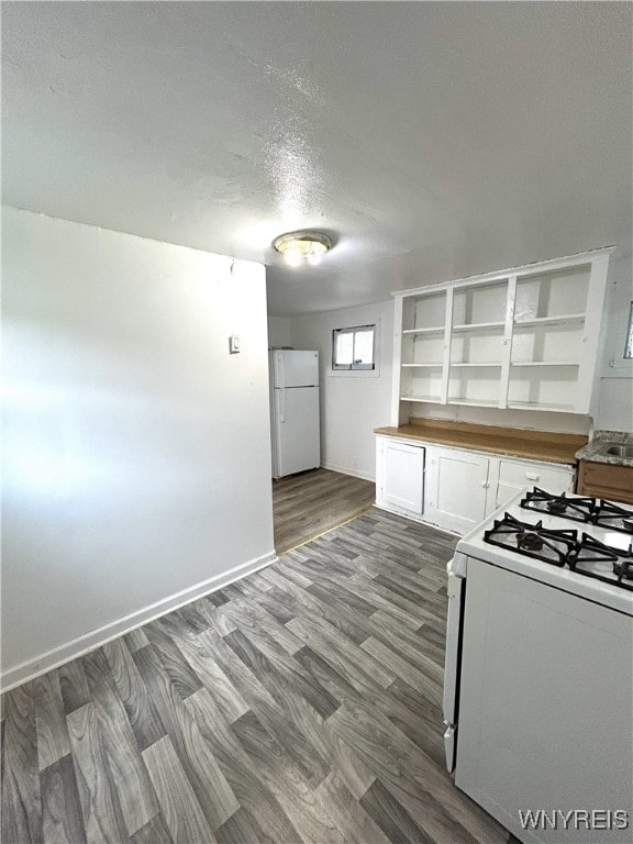 kitchen featuring a textured ceiling, white cabinetry, hardwood / wood-style flooring, and white appliances