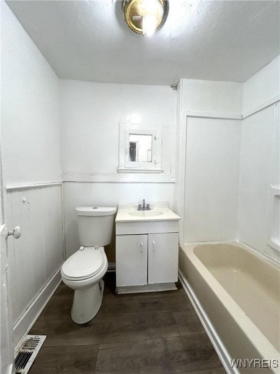 full bathroom with bathtub / shower combination, vanity, hardwood / wood-style flooring, and toilet