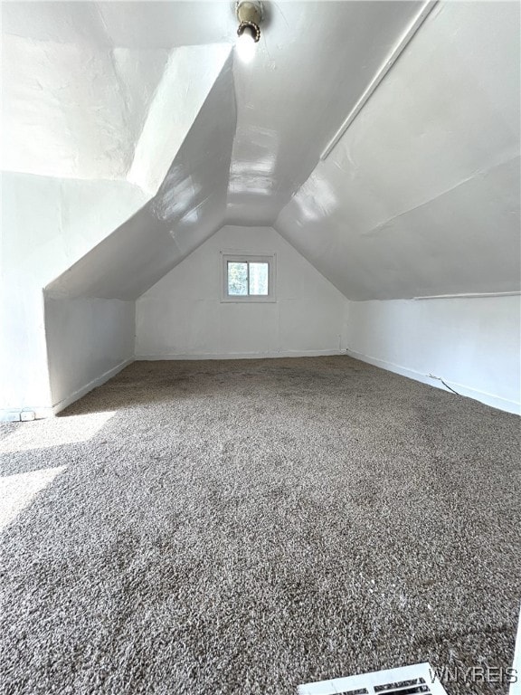 bonus room with lofted ceiling and carpet floors