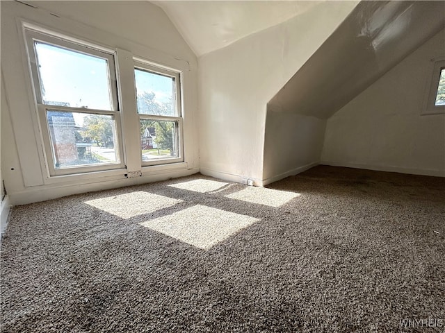 additional living space featuring lofted ceiling and carpet flooring