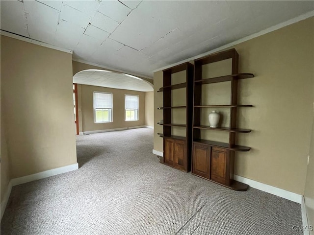 unfurnished room with ornamental molding and carpet