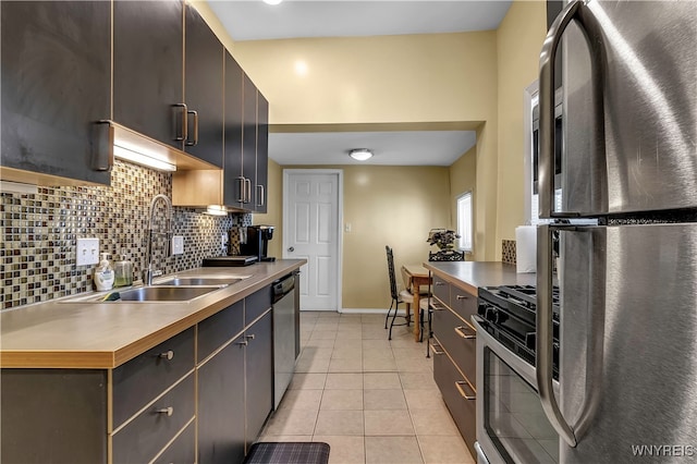 kitchen featuring appliances with stainless steel finishes, sink, dark brown cabinetry, decorative backsplash, and light tile patterned floors