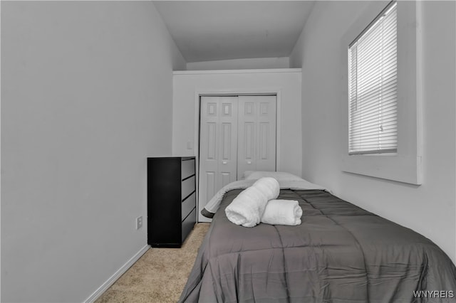 bedroom featuring light carpet and a closet