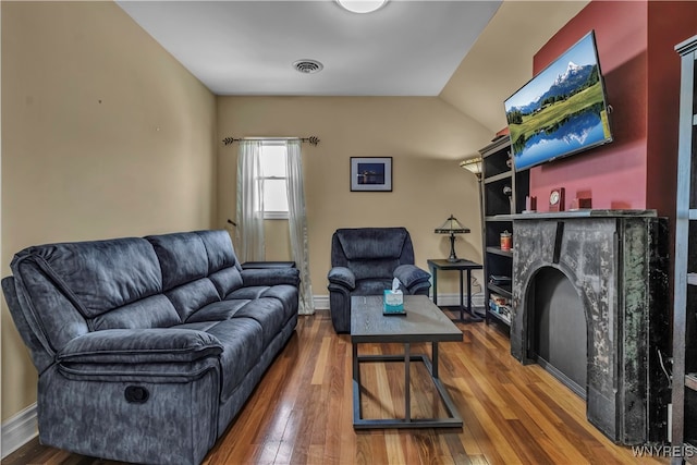 living room featuring vaulted ceiling and wood-type flooring