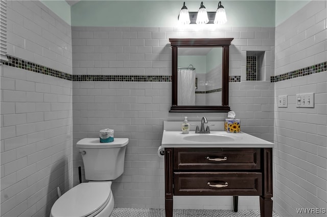 bathroom featuring toilet, tile walls, a shower with curtain, vanity, and tile patterned flooring