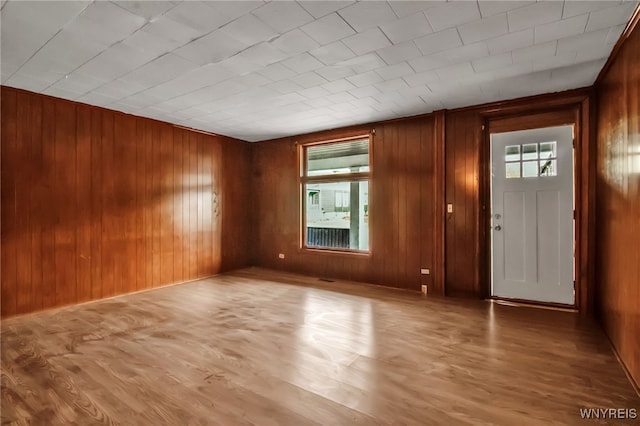 entryway featuring light hardwood / wood-style floors and wood walls