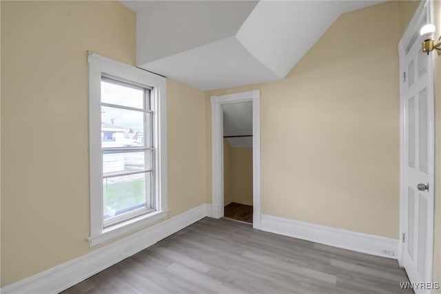 unfurnished bedroom with light hardwood / wood-style flooring, a closet, and vaulted ceiling