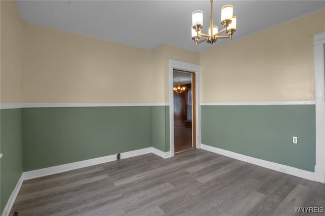 unfurnished room with hardwood / wood-style floors and a chandelier