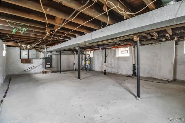 basement featuring heating unit, electric panel, and water heater