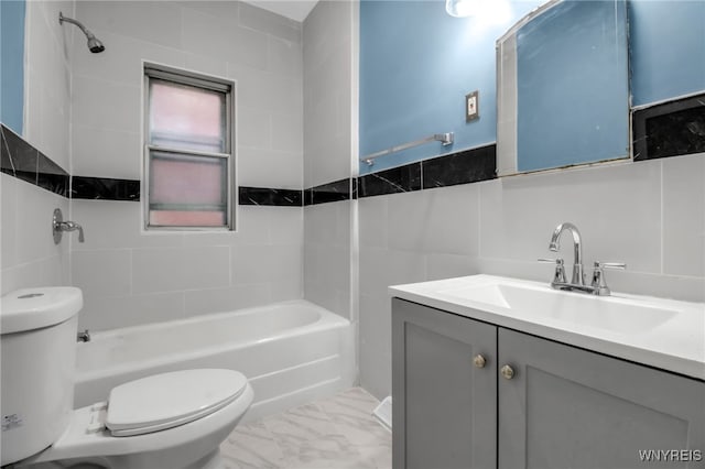 full bathroom featuring toilet, tiled shower / bath combo, vanity, and tile walls