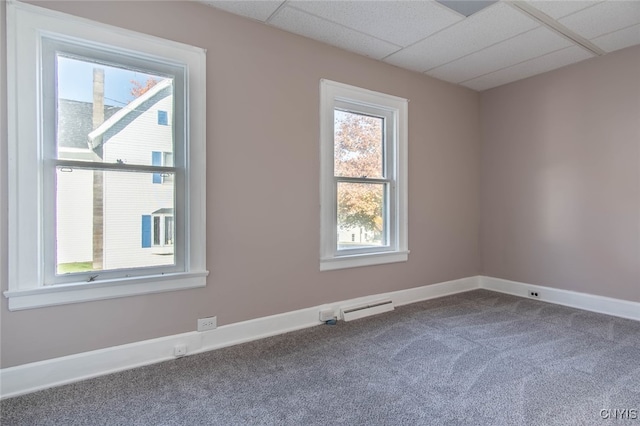 unfurnished room with carpet flooring, a drop ceiling, and plenty of natural light