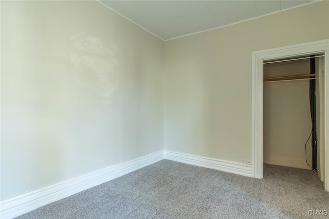 unfurnished bedroom with a closet and light colored carpet