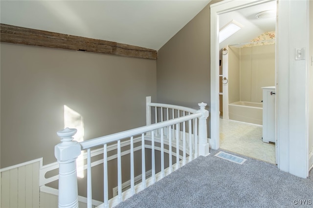 corridor featuring carpet and vaulted ceiling