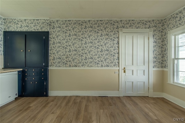 unfurnished bedroom featuring crown molding and light wood-type flooring