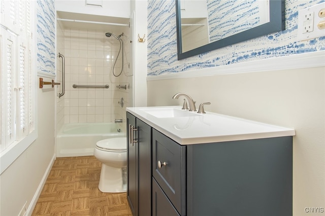 full bathroom with vanity, toilet, parquet flooring, and tiled shower / bath