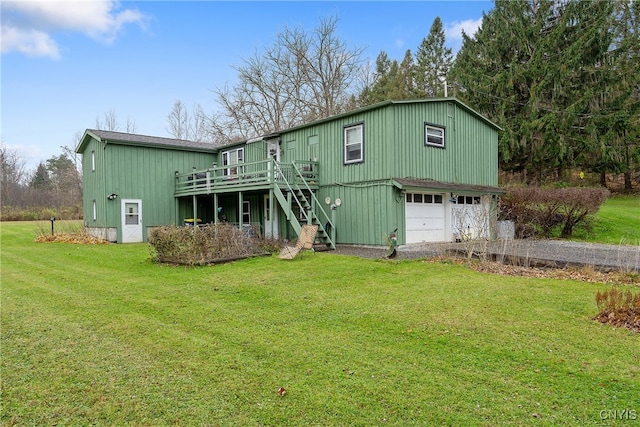 rear view of house with a yard, a deck, and a garage