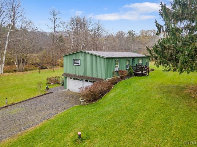 view of front of home with a front yard, a wooden deck, and a garage