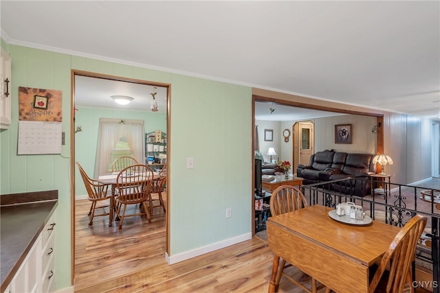 dining room with light hardwood / wood-style floors and crown molding