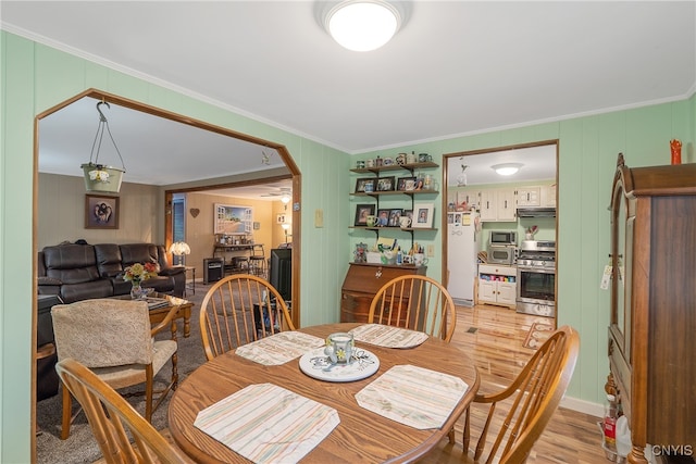 dining space featuring light hardwood / wood-style flooring and crown molding