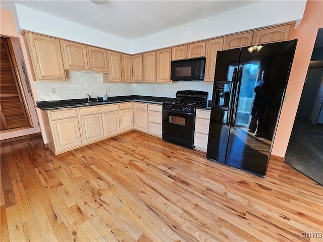 kitchen featuring light brown cabinets, sink, black appliances, light wood-type flooring, and tasteful backsplash