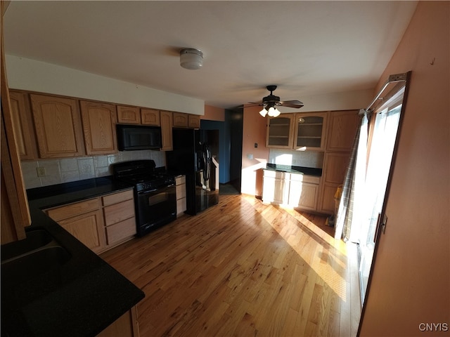 kitchen with light hardwood / wood-style floors, black appliances, decorative backsplash, and ceiling fan