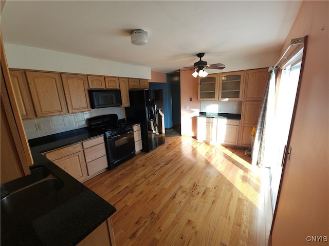 kitchen featuring black appliances, decorative backsplash, light hardwood / wood-style flooring, and ceiling fan