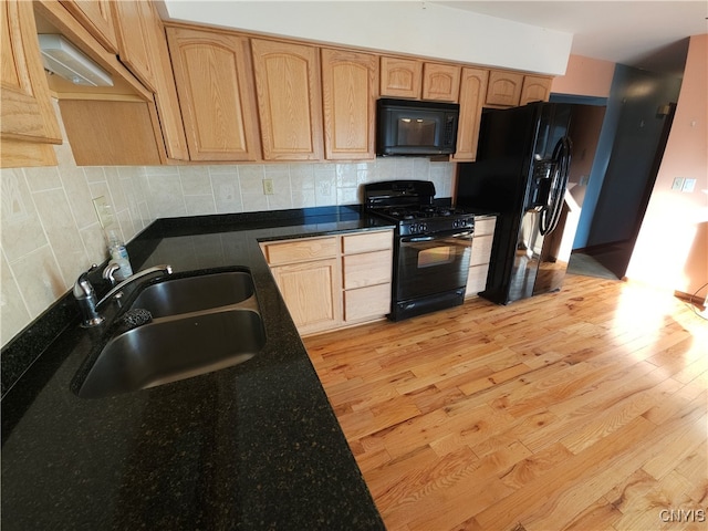 kitchen with black appliances, sink, light brown cabinetry, backsplash, and light hardwood / wood-style flooring