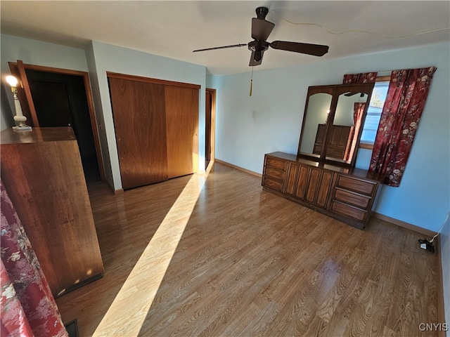 bedroom with dark hardwood / wood-style floors, a closet, and ceiling fan