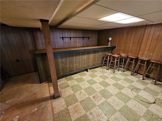 bar with wood walls and a drop ceiling