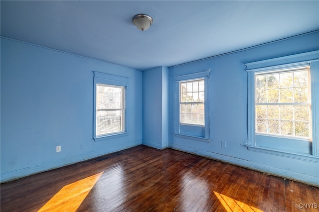 spare room featuring dark hardwood / wood-style floors and a wealth of natural light