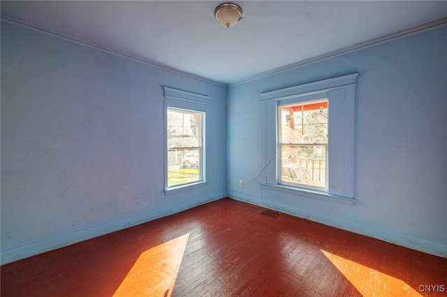 empty room featuring ornamental molding and hardwood / wood-style floors