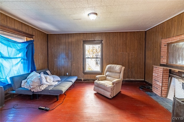 living area with dark wood-type flooring, crown molding, a fireplace, and wooden walls