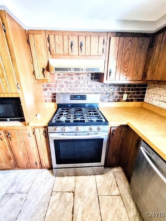 kitchen with appliances with stainless steel finishes and backsplash