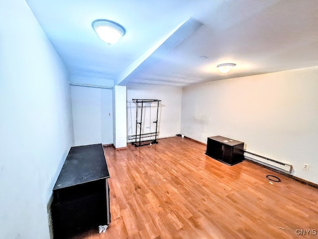 additional living space with hardwood / wood-style flooring and baseboard heating