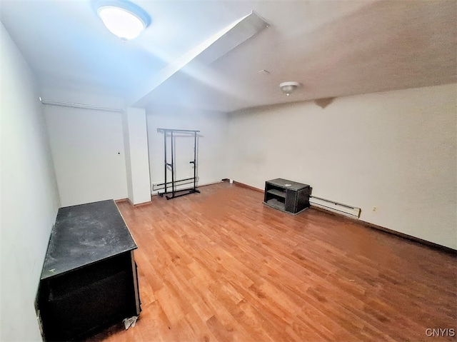 additional living space with a baseboard radiator and wood-type flooring