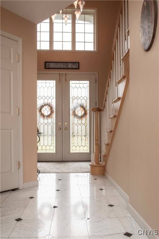 entryway with a towering ceiling and french doors