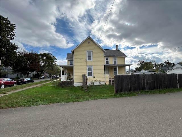 view of home's exterior with a porch and a lawn