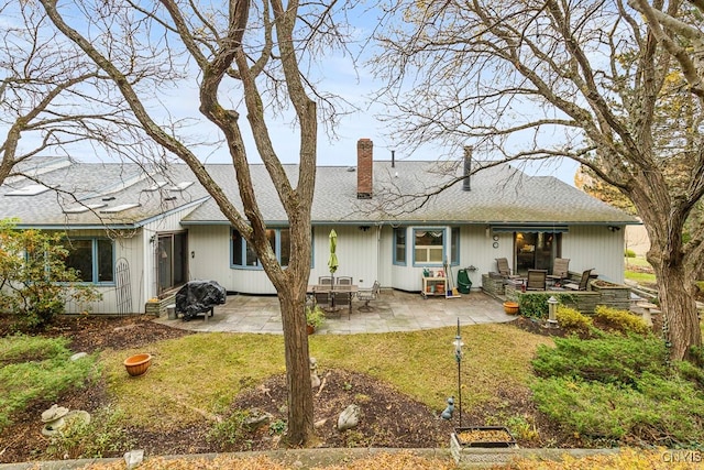 back of house with a patio area and a lawn