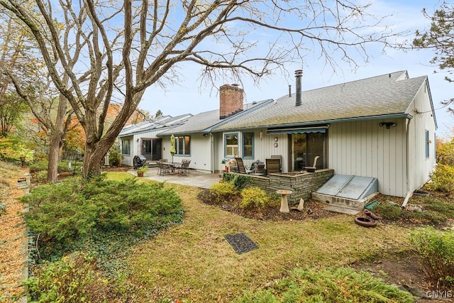 rear view of house with a patio area and a lawn