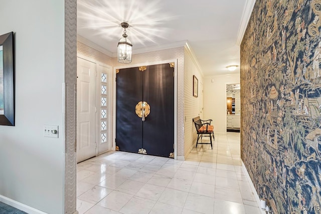 tiled foyer entrance with crown molding and a chandelier