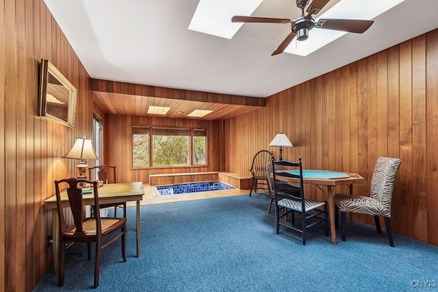 sitting room featuring wood walls and carpet floors