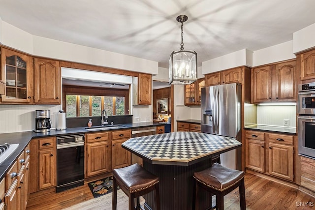 kitchen featuring sink, a kitchen island, dark wood-type flooring, a breakfast bar area, and an inviting chandelier