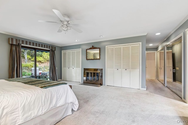 carpeted bedroom featuring crown molding, two closets, access to exterior, and ceiling fan