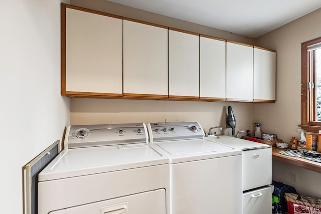 laundry area with independent washer and dryer and cabinets