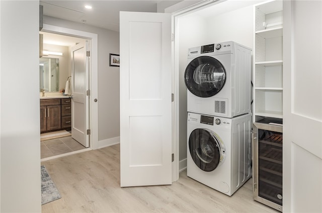 washroom with stacked washer / dryer, wine cooler, sink, and light wood-type flooring