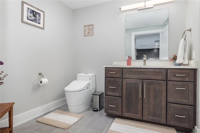 bathroom with toilet, vanity, and tile patterned floors