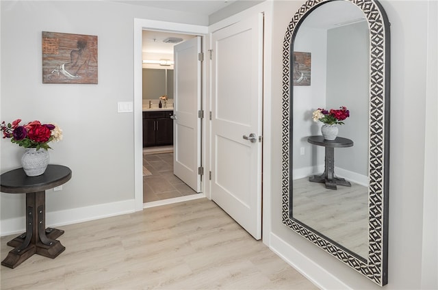 corridor featuring light hardwood / wood-style floors and sink