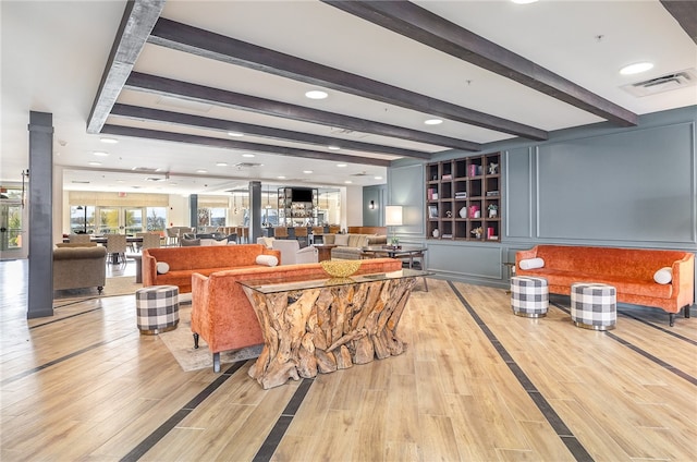 living room with light hardwood / wood-style floors and beamed ceiling